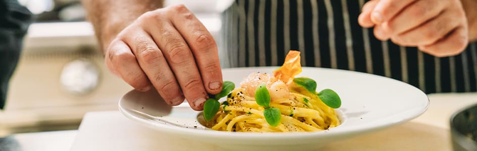 Préparation d’un plat de pâte par un restaurateur
