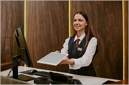 Réceptionniste à l’hôtel qui tend une tablette