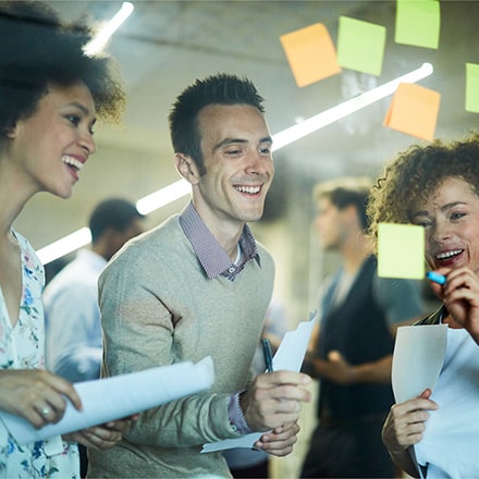 Un homme et deux femmes faisant un brainstorming