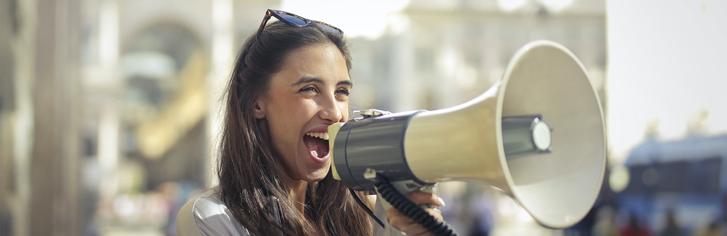Femme souriante parlant dans un mégaphone