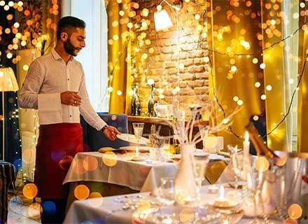 Serveur dressant une table festive dans un restaurant