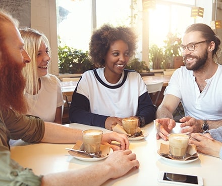Groupe de personnes souriantes au café