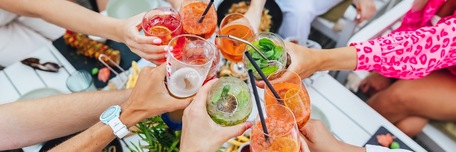 Groupe d'amis trinquant avec leurs cocktails