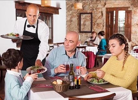 Serveur apportant le plat à un enfant dans un restaurant