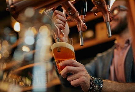 Barman versant une bière dans un verre