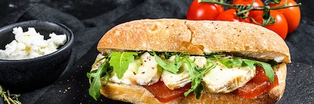 Sandwich dans un pain ciabatta avec du fromage et des tomates