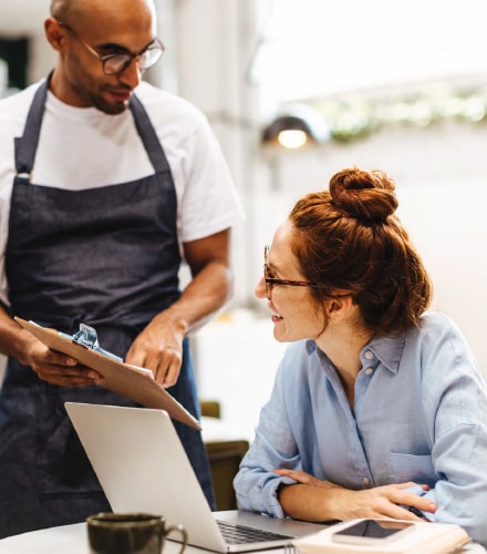Un serveur et une restauratrice regardant un document