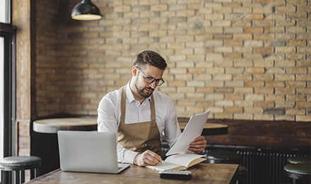 Un restaurateur regarde un document devant son ordinateur