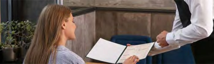 Serveur qui présente une carte de restaurant à une cliente