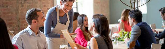 Serveuse à la table d'un restaurant