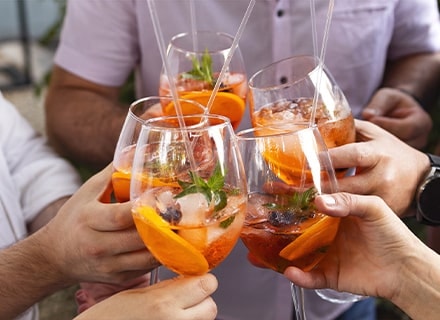 Amis trinquant avec des verres de cocktails aux fruits