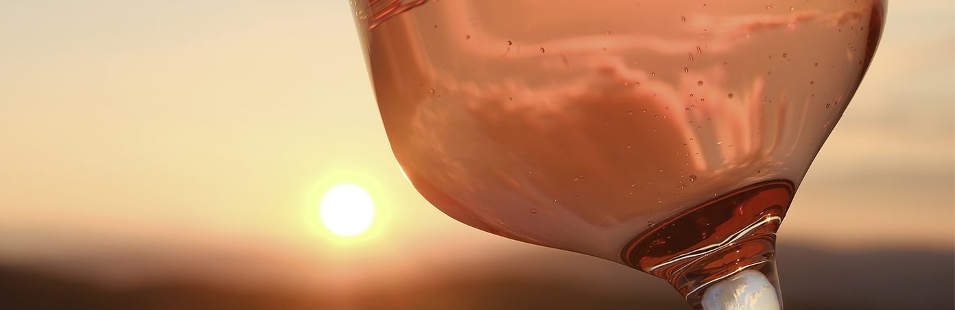 Verre de vin rosé devant le soleil couchant