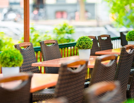 Tables de terrasse de restaurant avec une décoration végétale artificielle