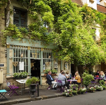 Terrasse de restaurant fleurie installée sur un trottoir