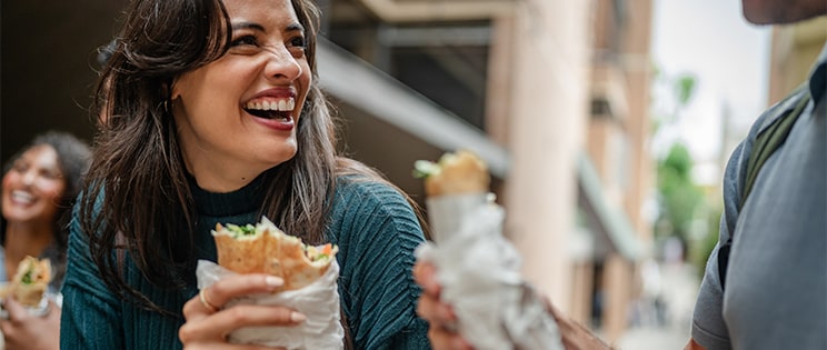 Jeune femme qui mange un sandwich en extérieur