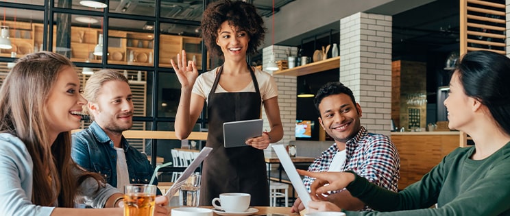 Une serveuse prend les commandes des clients à table