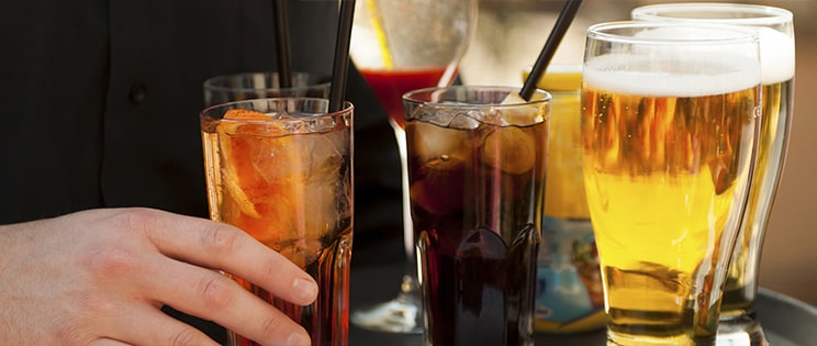 Verres de bière, soda et jus de fruits sur un plateau