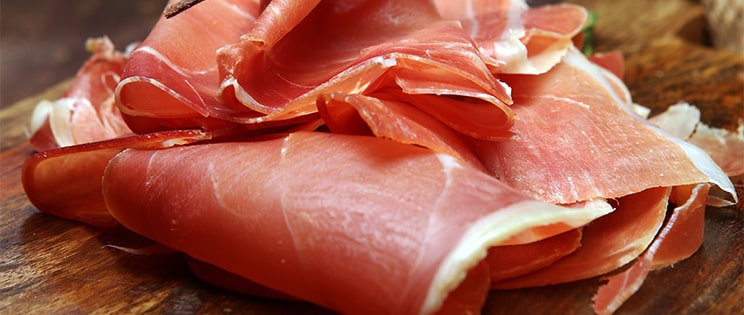 Tranche de jambon sec sur un plateau en bois