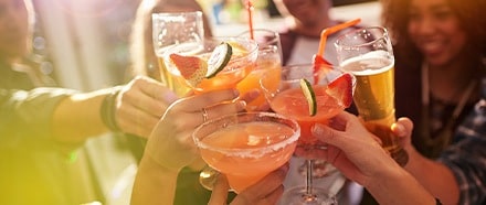 Groupe de personnes qui trinquent avec des cocktails