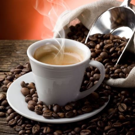 Rioba cafea boabe pentru rasnita de cafea langa ceasca de espresso fierbinte