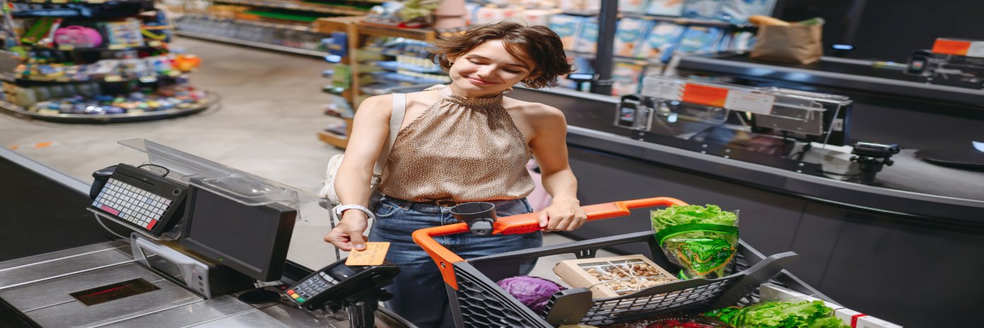 Kobieta dokonująca płatności kartą w sklepie