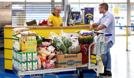 Cliente com carrinho cheio a pedir ajuda a colaborador makro