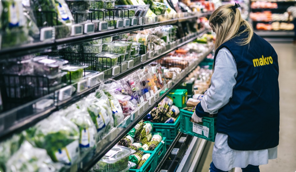 Colaboradora makro a arrumar uma caixa na prateleira