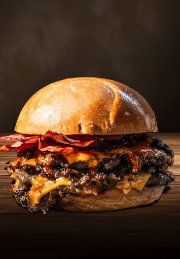 Burger gourmet cu carne de vită suculentă, bacon crocant și brânză topită, ideal pentru meniuri HoReCa profitabile