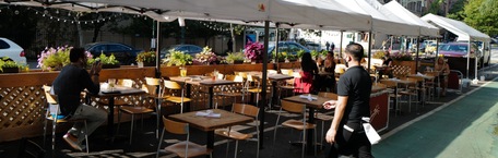 Oameni care stau la terasa unui restaurant