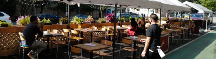 Oameni care stau la terasa unui restaurant