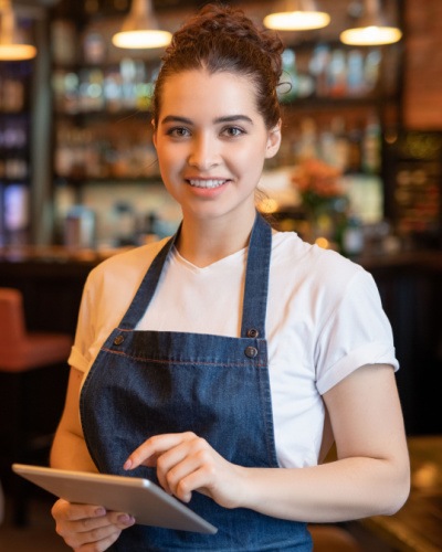 Un lucrator de restaurant tine o tableta in mana