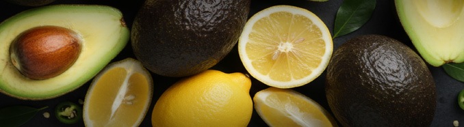 Avocado întregi și felii de lămâie pe fundal negru – fructe și legume proaspete METRO.