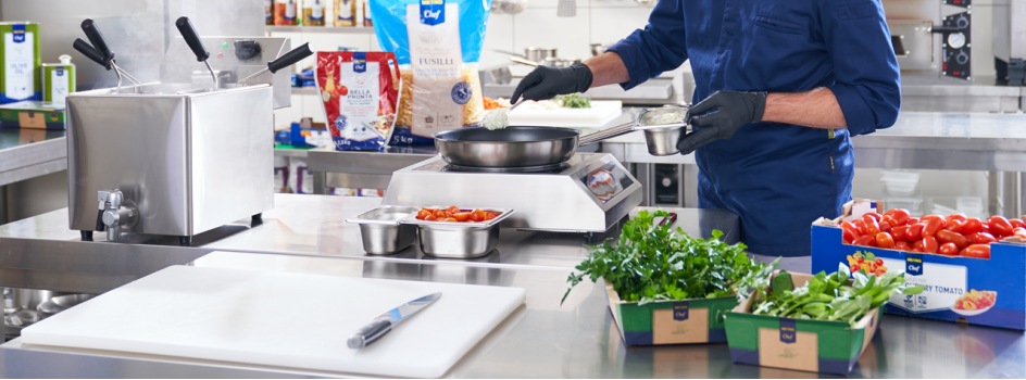 Chef gătește paste într-o bucătărie profesinală