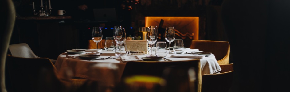 Masă din restaurant aranjată cu farufrii și pahare de vin