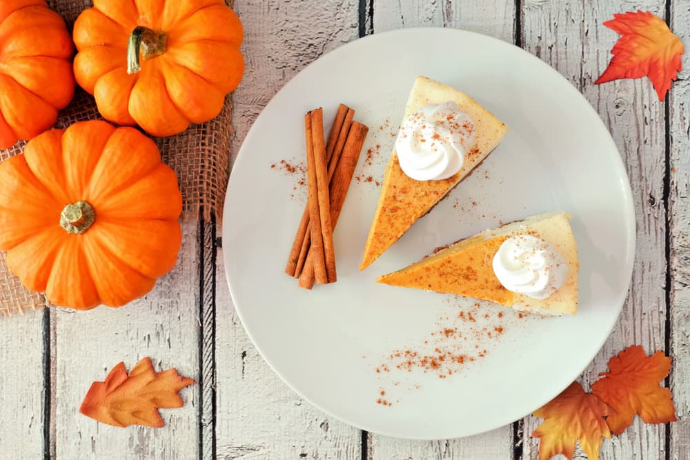 Гарбузовий чізкейк з вершками та корицею на білому тарілці