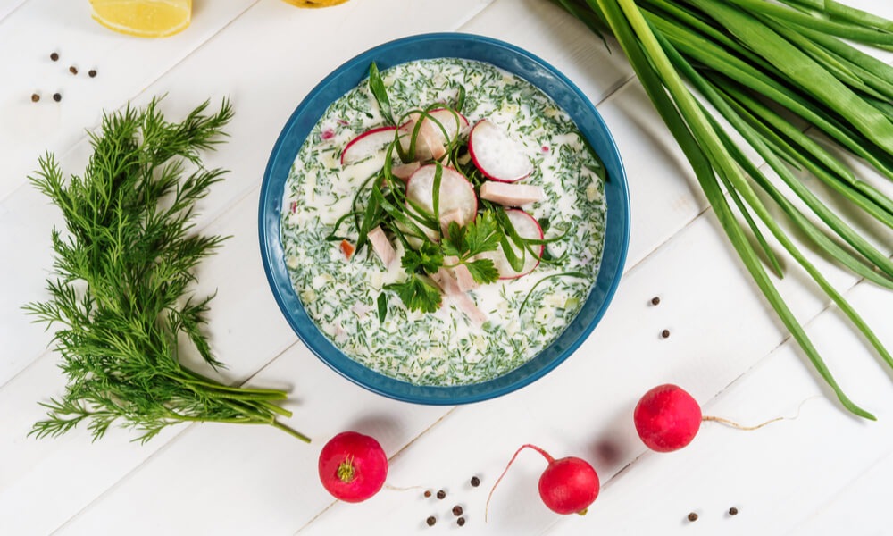 Тушкована капуста кале з гарбузом на тарілці – тепла страва з обсмаженим гарбузом і капустою кале на білому посуді.