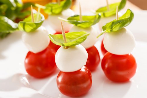 Закуска капрезе на шпажках: міні-моцарела, чері та базилік — свіжо, яскраво, ідеально для фуршету.