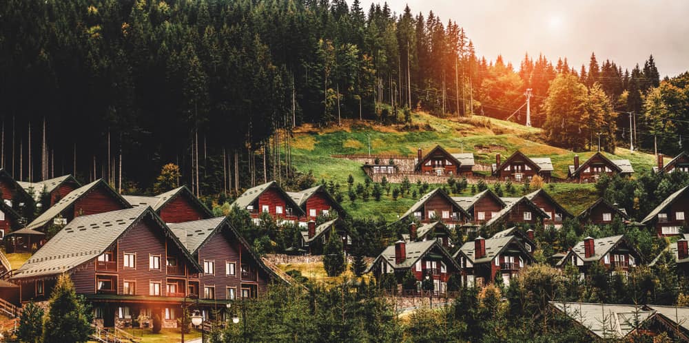 Дерев'яні шале на гірському схилі в Буковелі на заході сонця