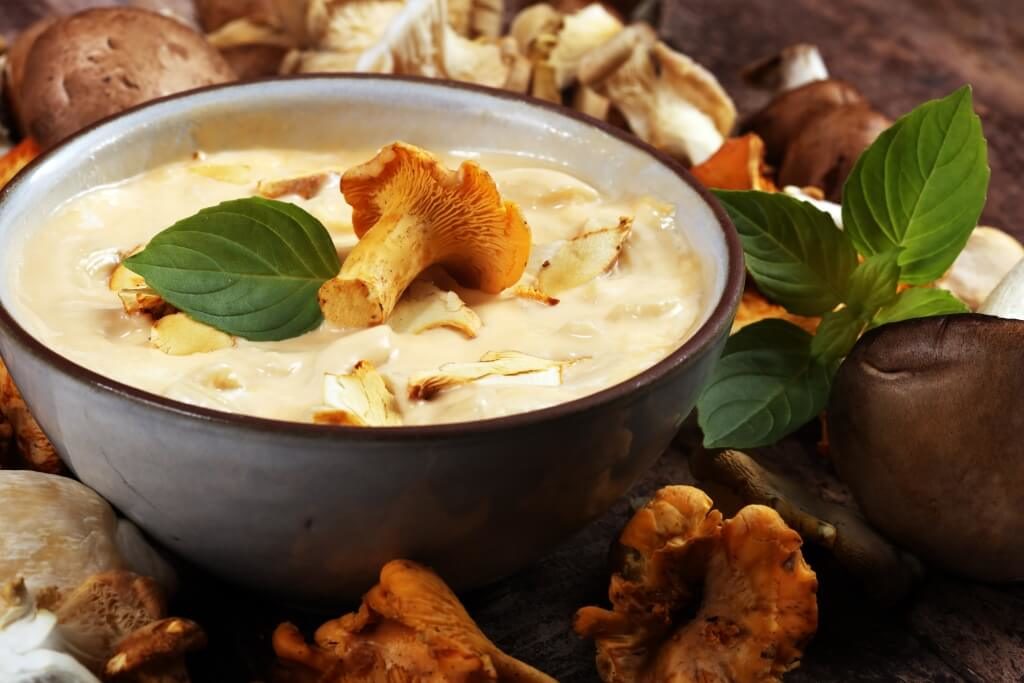 Грибний соус із лисичками в мисці, прикрашений листям базиліку