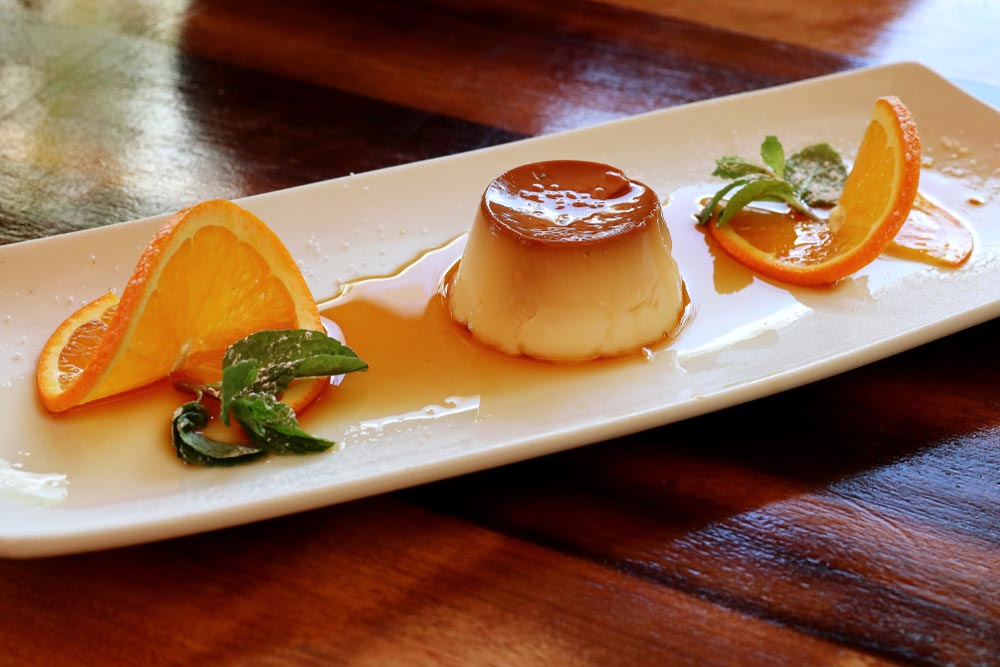 Флан із карамельним соусом і апельсинами на прямокутній тарілці