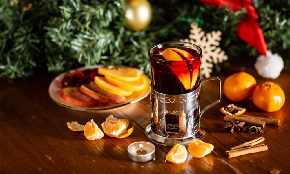 Глінтвейн із апельсинами в новорічній атмосфері — святковий напій на фоні ялинки