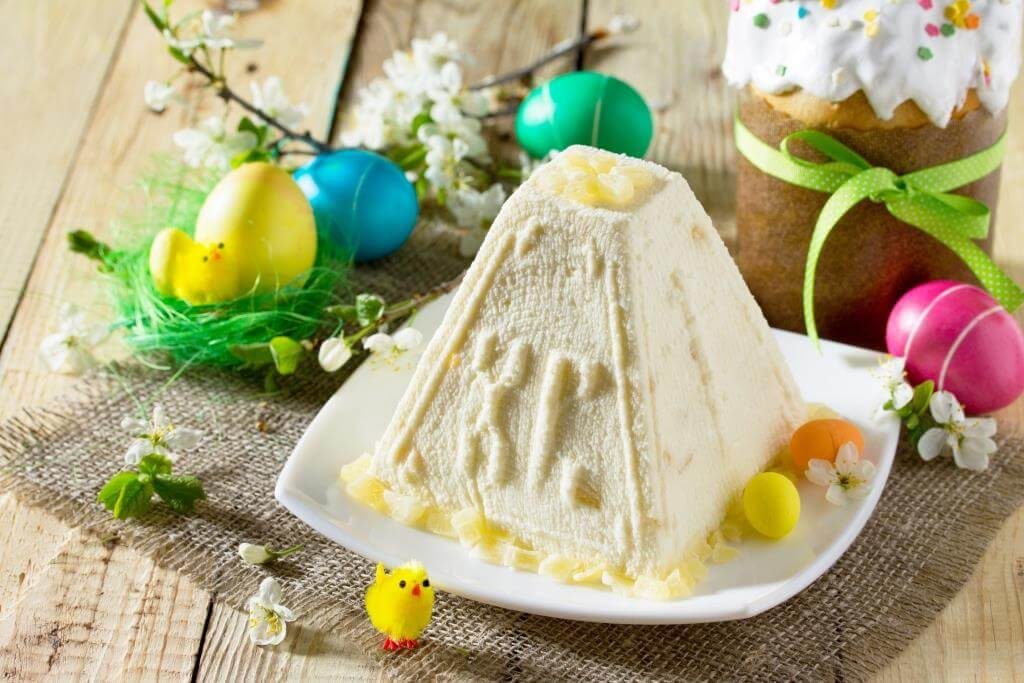 Традиційна пасха з творогу у формі піраміди з літерами "ХВ", поруч крашанки, паска та великодній декор