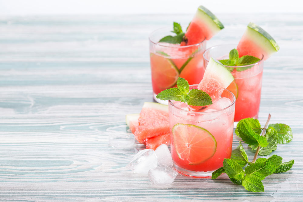 Освіжаючий напій з кавуна, лайма, м'яти та льоду в склянках.
