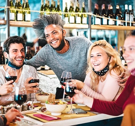 Hommes et femmes buvant un verre de vin au restaurant